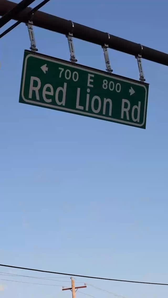 The green Red Lion Rd street sign against a clear sky.